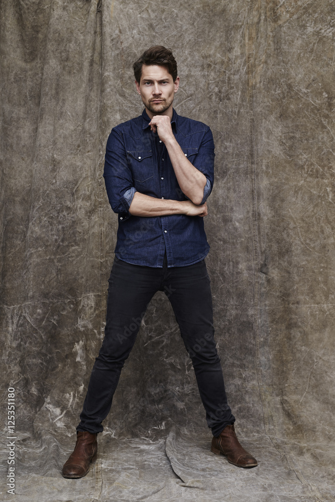 Man in jeans and shirt posing for camera Man in jeans and shirt posing for camera