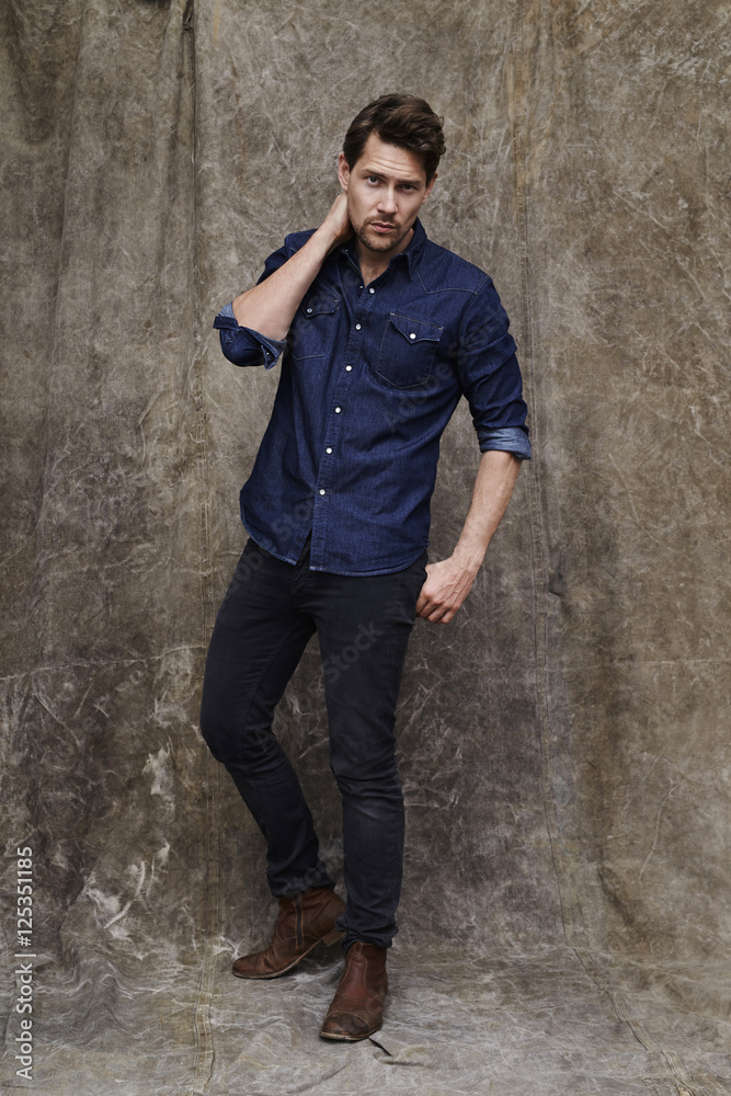 Posing dude in denim looking at studio Posing dude in denim looking at studio