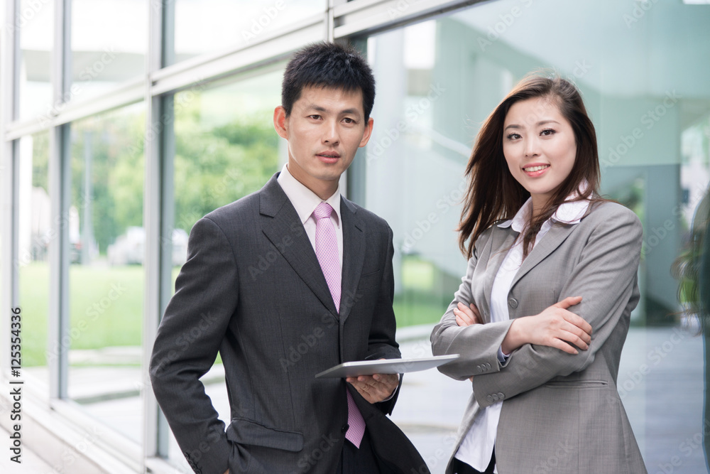 asian beautiful girl and businessman with tablet in modern hall asian beautiful girl and businessman with tablet in modern hall