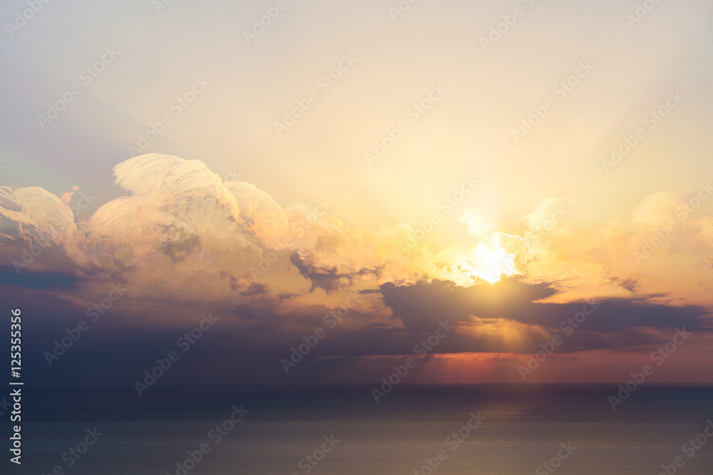 Blue sky with clouds, sea and sun on the horizon