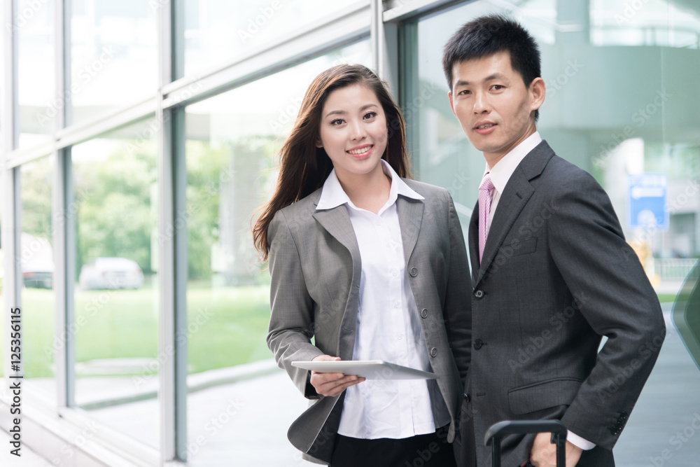 asian beautiful girl and businessman with tablet in modern hall asian beautiful girl and businessman with tablet in modern hall