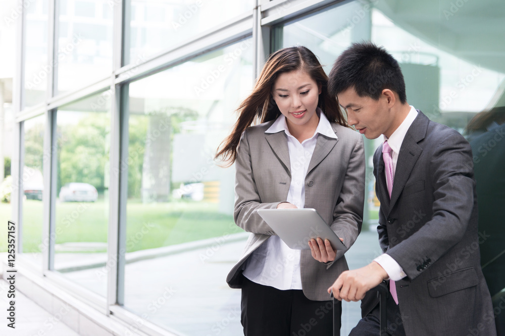 asian beautiful girl and businessman with tablet in modern hall asian beautiful girl and businessman with tablet in modern hall
