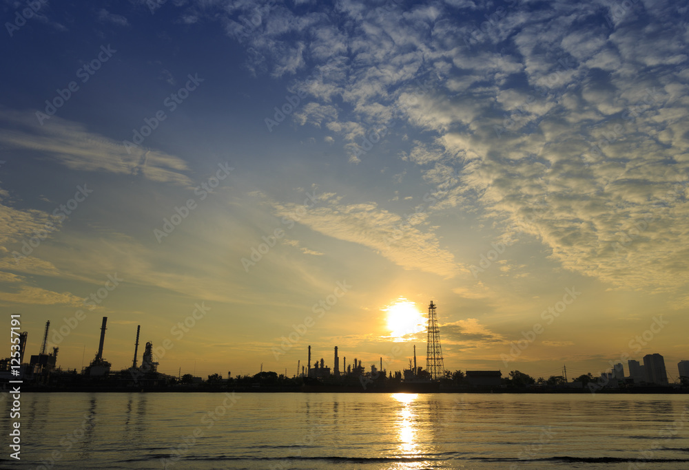 Bangchak Petroleum's oil refinery in Silhouette, beside the Chao Phraya River, Petrochemical industrial with sunrise background in Phra Khanong District, Bangkok, Thailand