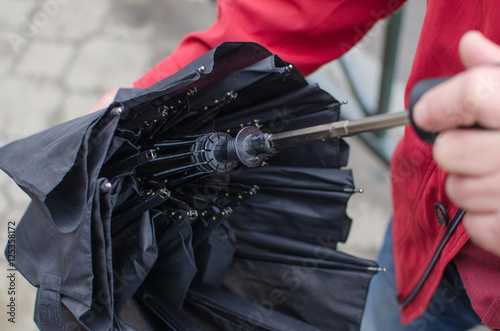 Man closing umbrella