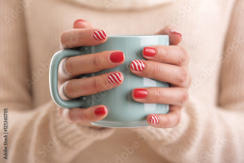 Women's hands holding a cup of drink.