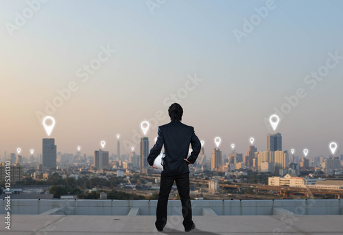 businessman stand on roof top of skyscrabber, network connection