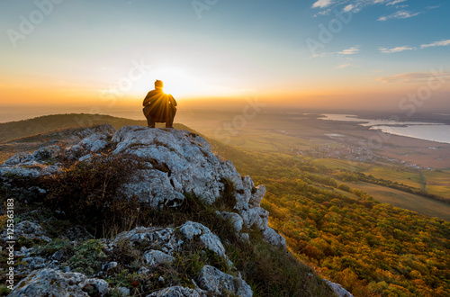 Man sitting on the top of Devin mountain and watching sunset, Palava, South Moravia, Czech Republic photo