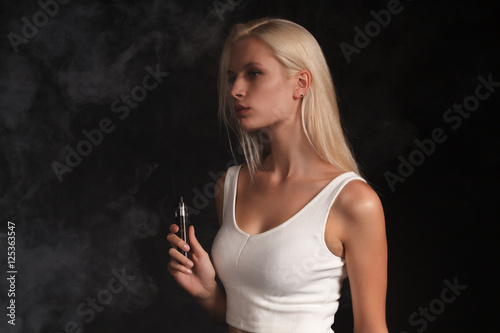beautiful bright young woman smoking electronic cigarette