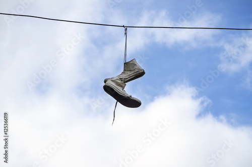 Fotografie The old sneakers hanging on wires.