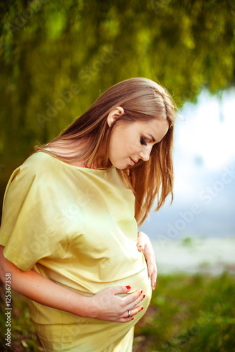 Beautiful pregnant woman holding her belly