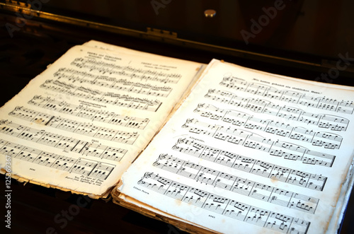 open big old music song book on the table photography