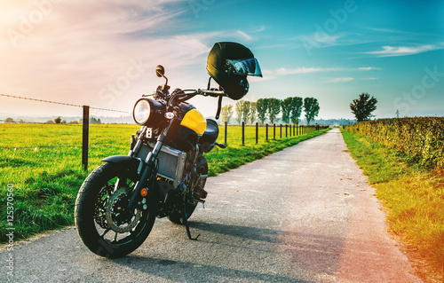 Motorrad fährt auf freier Landstrasse in den Sonnenuntergang 
