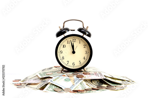 Time is money concept with close up of an old clock on dollar bills