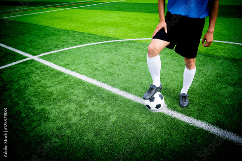 Soccer player ready to play at kick off point in soccer field.