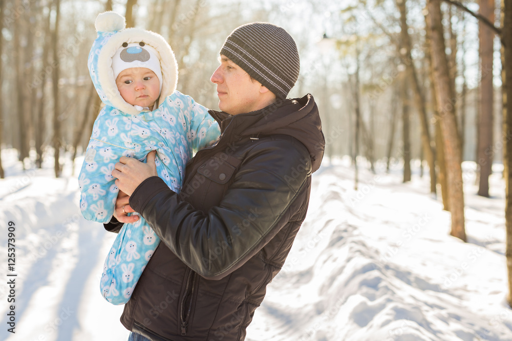 Happy father playing with little child son boy in winter nature
