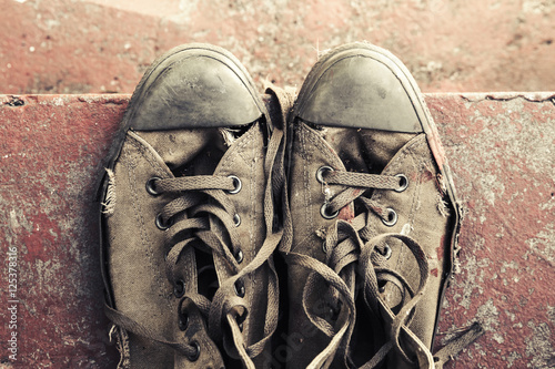 Old sneakers stand on concrete stairs