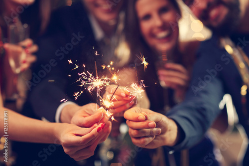 Group of friends having fun with sparklers photo