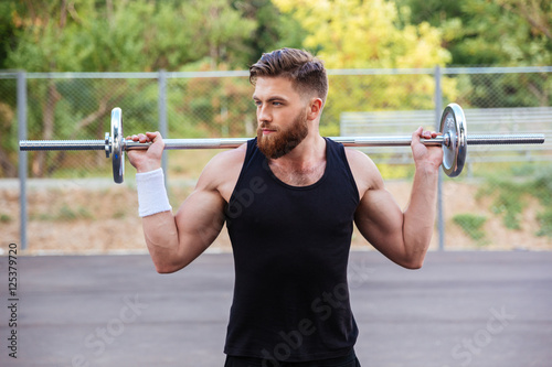Portrait of a muscular man workout with barbell