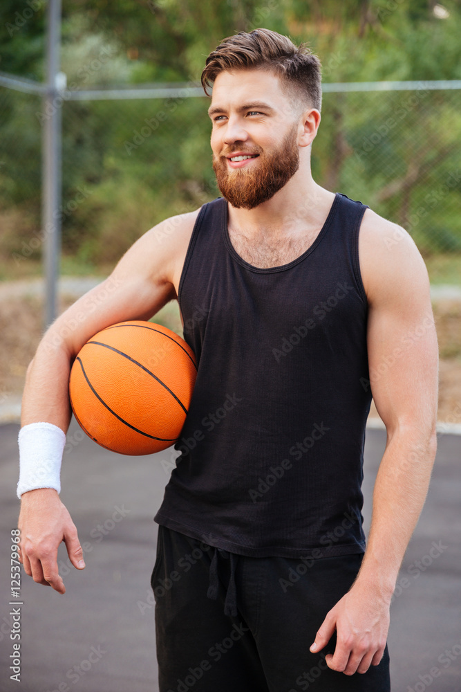 Cheerful happy basketball player standing with ball