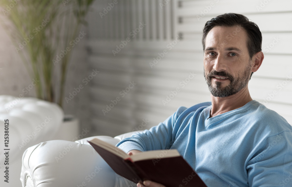 Fotografie Nice delighted man reading a story