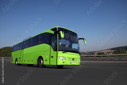 Fernbus fährt auf einer Autobahn in schöner Landschaft zum Reiseziel 