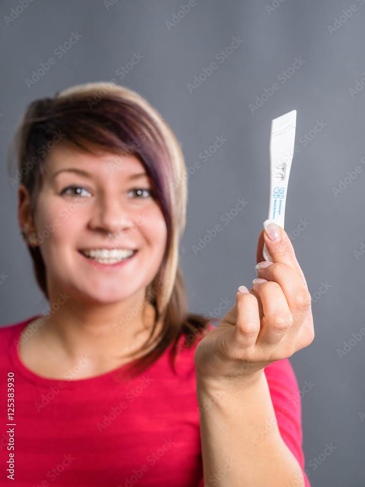 Joyful and surprised woman showing positive pregnancy test Joyful and surprised woman showing positive pregnancy test