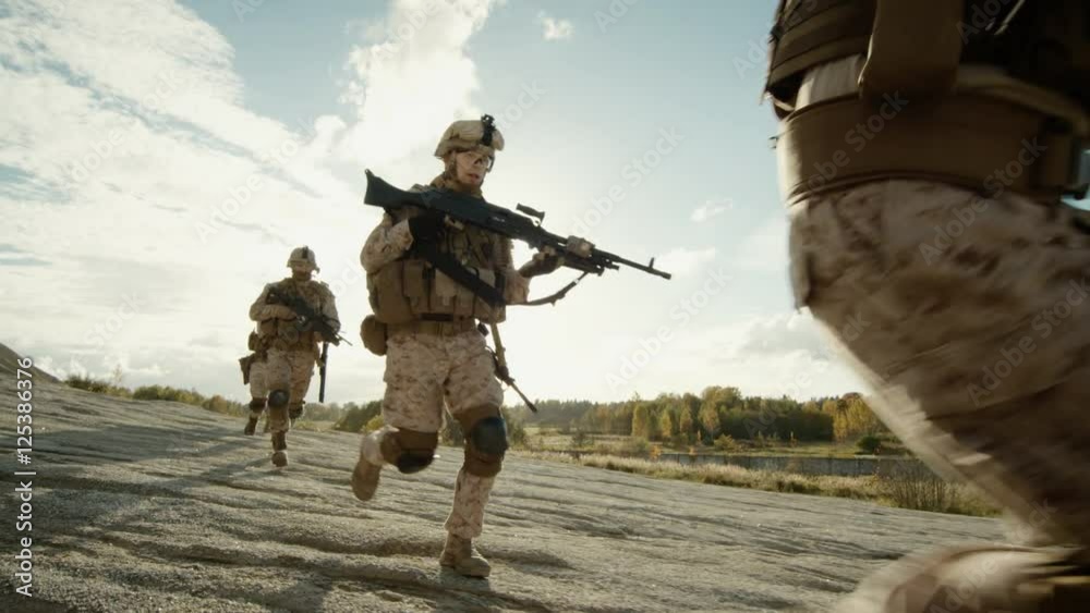 Squad of Fully Equipped and Armed Soldiers Running in Single File in the Desert.