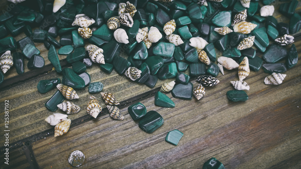 Malachite on wooden background, small shells on a wooden backgro Malachite on wooden background, small shells on a wooden backgro