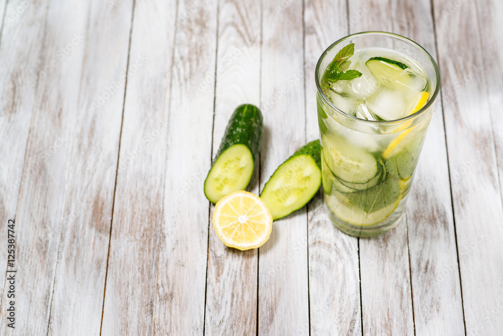 Water with lemon, mint and cucumber on wooden light background. Water Detox. Water with lemon, mint and cucumber on wooden light background. Water Detox.