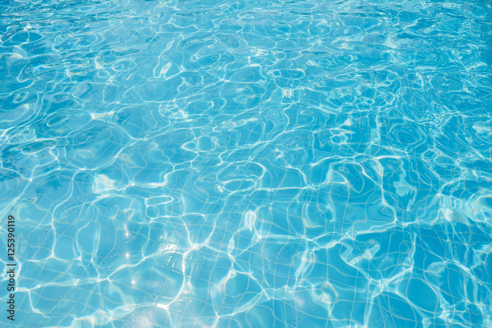 Ripple water in swimming pool witn sun reflection