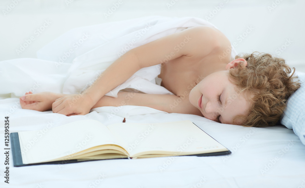 Obraz premium Boy fell asleep on the entries in the notebook.