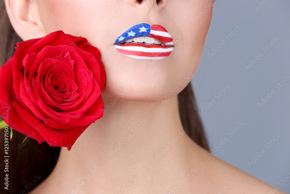 Girl with USA makeup and red rose on grey background Girl with USA makeup and red rose on grey background