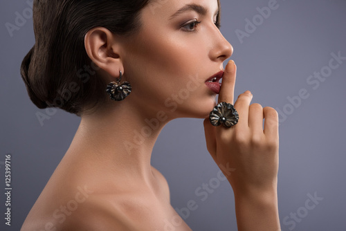 Gorgeous woman with precious jewelry in studio