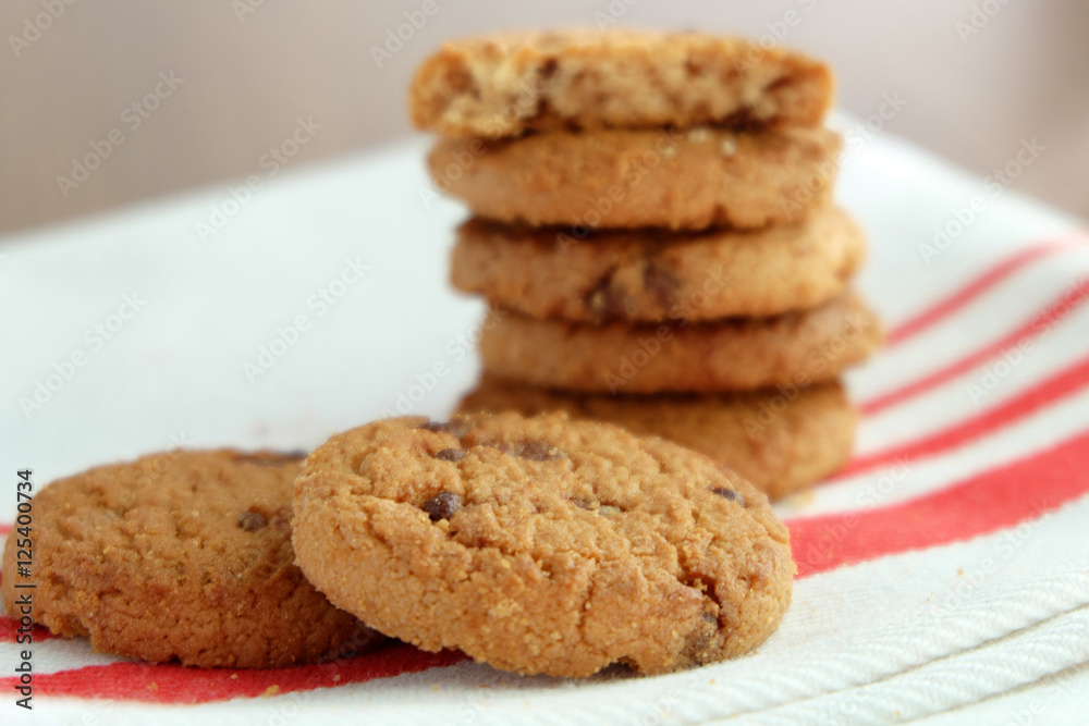 Chocolate chip cookies on white linen napkin on wooden tab Chocolate chip cookies on white linen napkin on wooden tab