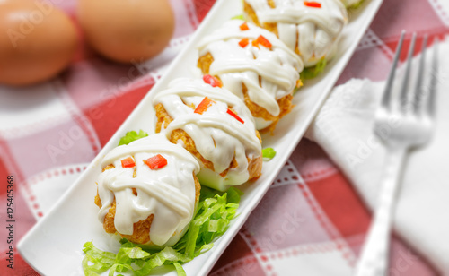 Stuffed eggs with tuna, tomato, mayonnaise and red pepper on red