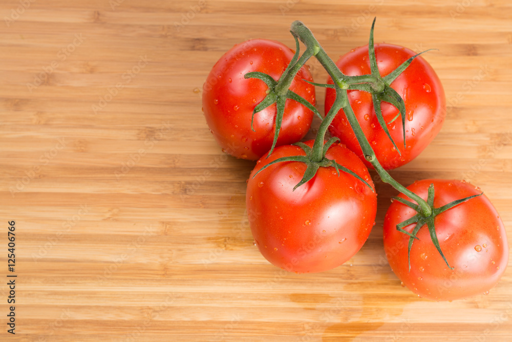 Fresh red tomatoes on a branch. Tomatoes with water drops. Fresh red tomatoes on a branch. Tomatoes with water drops.