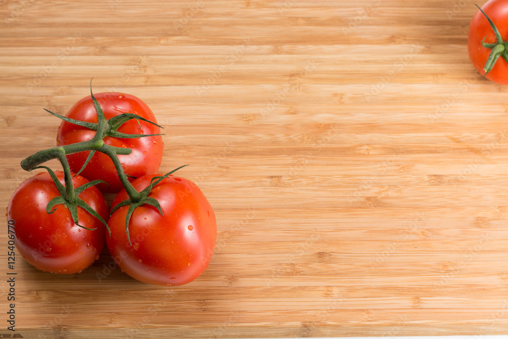Fresh red tomatoes on a branch. Tomatoes with water drops. Fresh red tomatoes on a branch. Tomatoes with water drops.