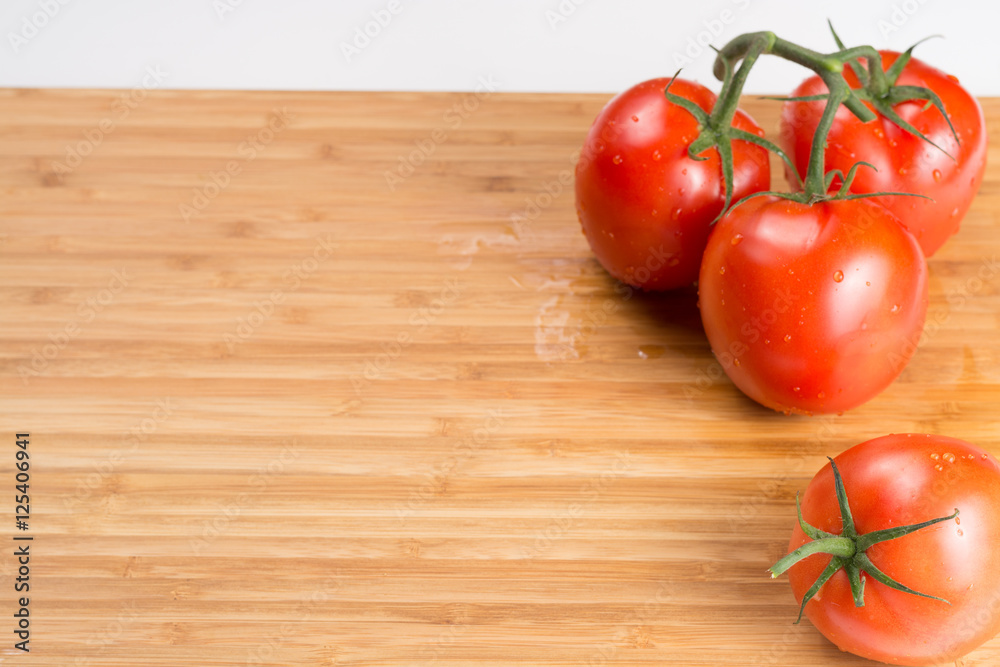 Fresh red tomatoes on a branch. Tomatoes with water drops. Fresh red tomatoes on a branch. Tomatoes with water drops.