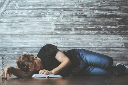 Man with book sleeping on floor
