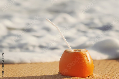 coconut cocktail on  sandy  beach next to the indian ocean.  travel (vacation) concept