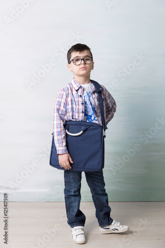 Photos serious little boy with shoulder bag ilke grown-up in  glasses