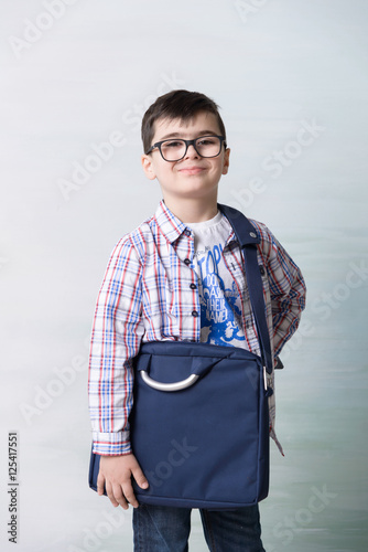 фотографія serious little boy with shoulder bag ilke grown-up in  glasses