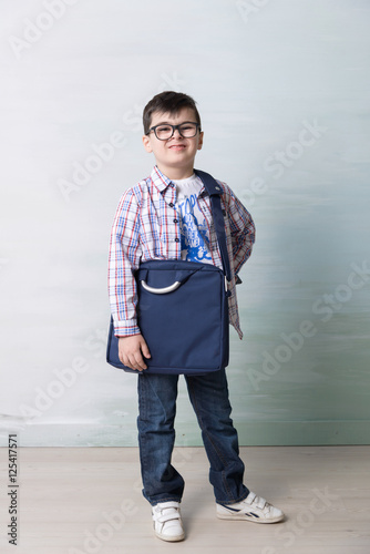 Obraz na plátně serious little boy with shoulder bag ilke grown-up in  glasses