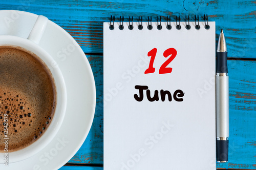 June 12th. Image of june 12 , calendar on blue background with morning coffee cup. Summer day, Top view photo