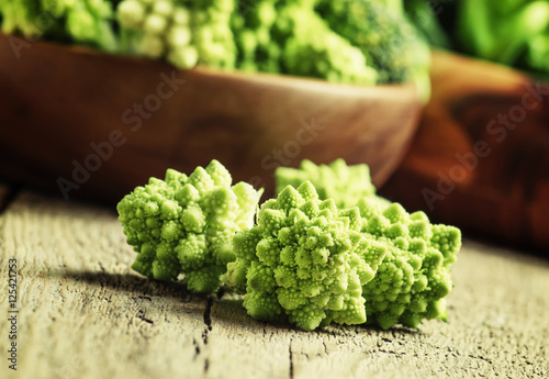 Green cauliflower, old wooden background, selective focus