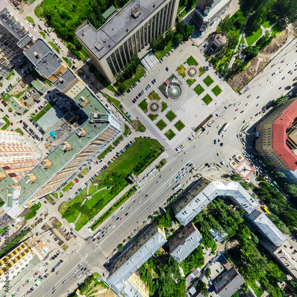Fototapeta premium Aerial city view with crossroads and roads, houses, buildings, parks and parking lots, bridges. Copter shot. Panoramic image.