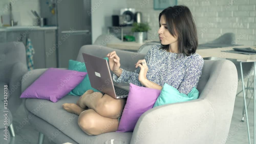 Young woman finishing working on laptop and relaxing on sofa at home
Young woman finishing working on laptop and relaxing on sofa at home