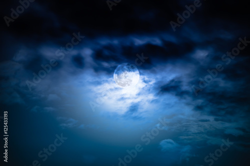 Nighttime sky with clouds and bright full moon with shiny. © kdshutterman