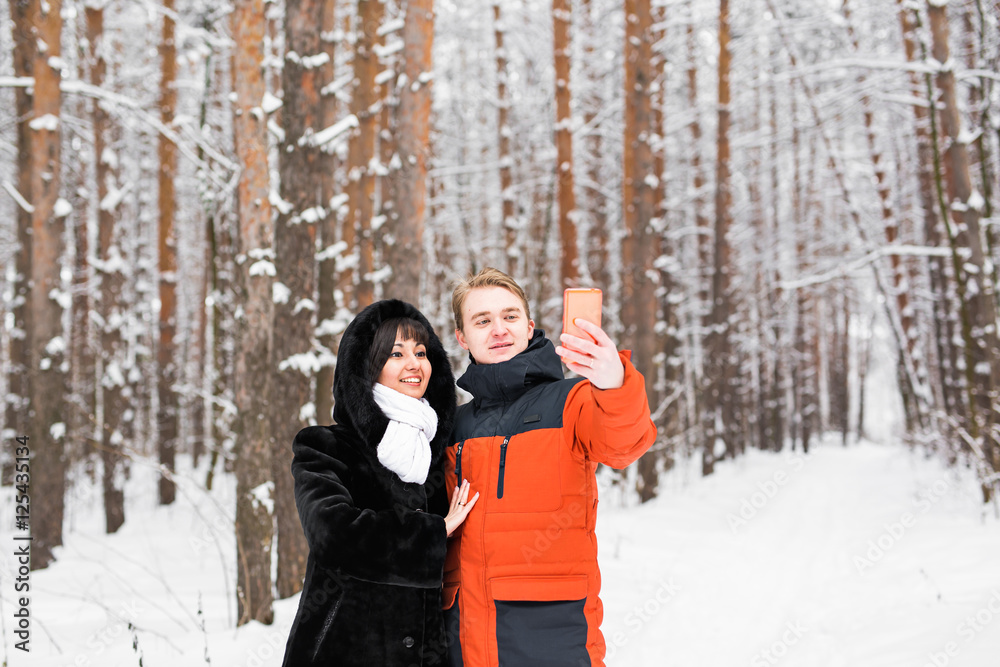happy couple taking selfie by smartphone in winter happy couple taking selfie by smartphone in winter