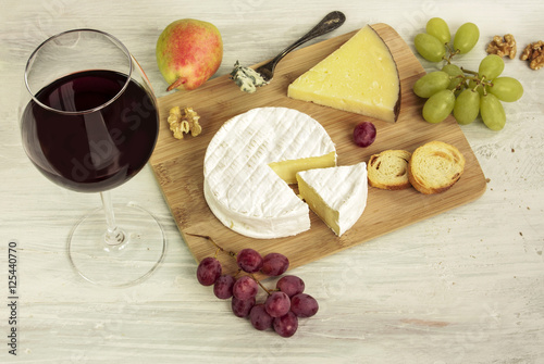 Red wine with many different types of cheeses and grapes